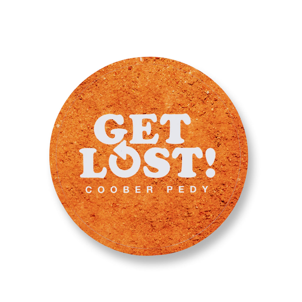 round orange sticker reading get lost coober pedy 
