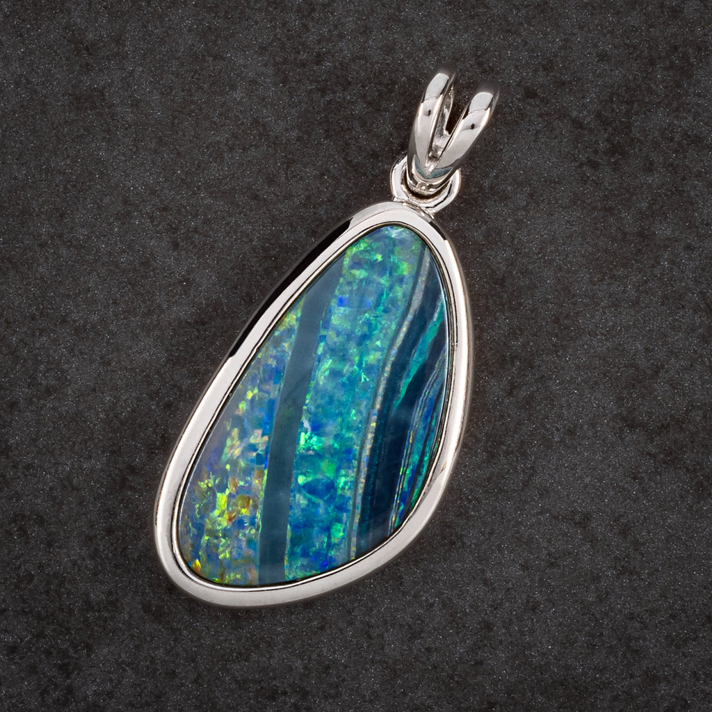 round silver pendant with blue and green stripey opal 