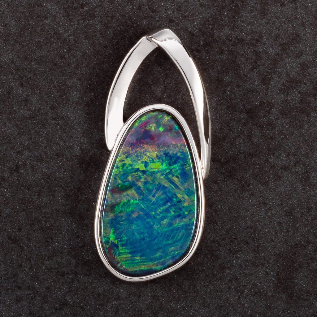 round silver pendant with blue red and green opal